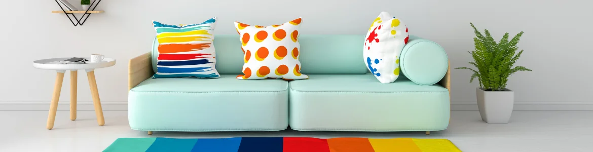 home-staging-3 Light aqua sofa with colourful cushions atop rainbow-coloured rug with potted plant and side table
