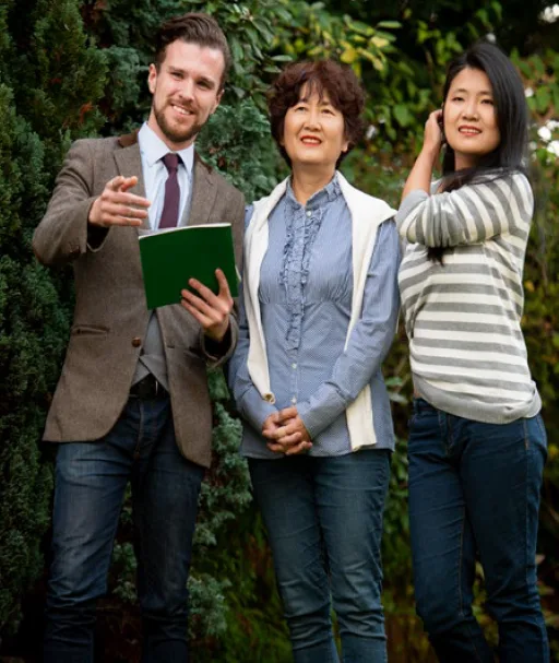 A man in suit showing a property off camera to an older woman and a younger woman